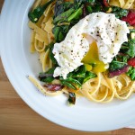 wilted greens and pasta with a poached egg in a browned lemon butter sauce